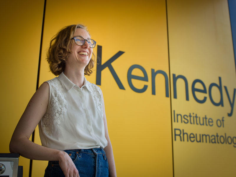 Helena stood in front of the Kennedy Institute of Rheumatology sign