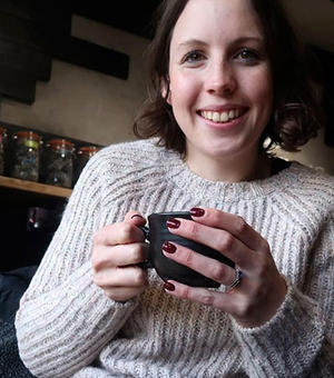 Kate Bunce holding coffee in cafe